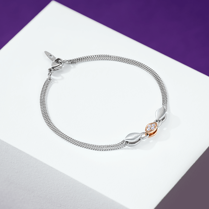 This sleek platinum bracelet features delicately intertwined links anchored by a striking pellet centerpiece. 